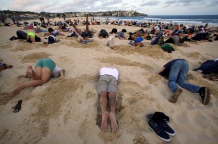 Автралийцы протестуют: более 400 человек зарыли свои головы в песок на пляже Бонди. Фото