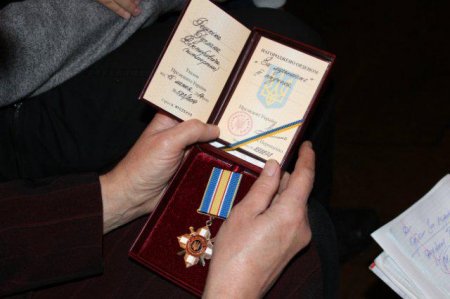 В маленьких ручках орден Мужества, в память о погибшем отце Руслане Редькине. Фото